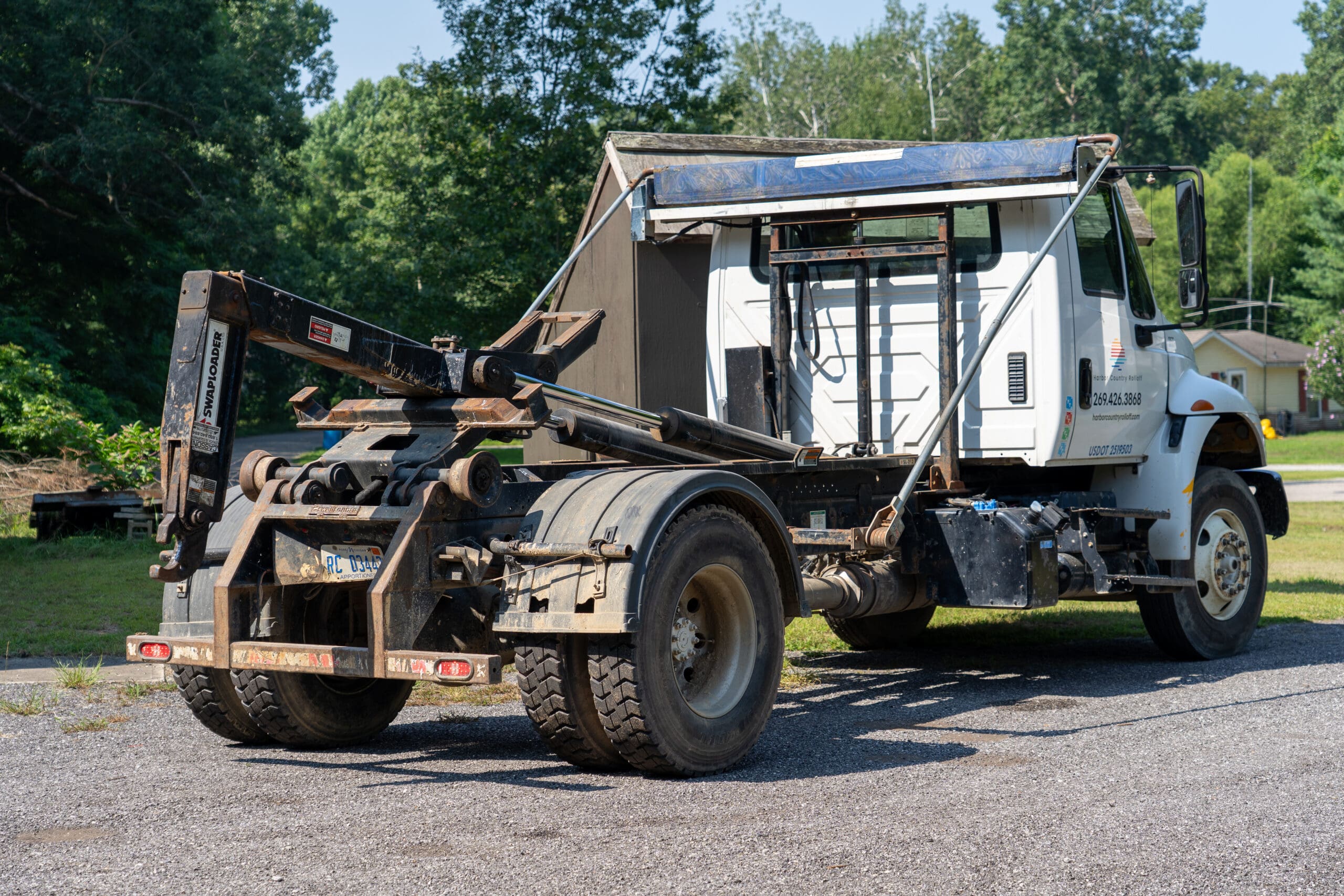 Close-up of a roll-off dumpster truck with a Swap Loader hoist system, used by Harbor Country Rolloff for dumpster delivery and pickup.